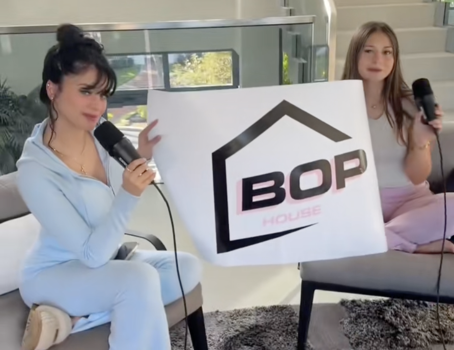 screenshot of a TikTok video showing two models in athleisure holding a banner reading "BOP"