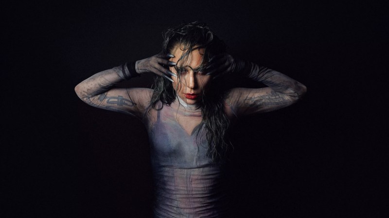 Photo of Lady gaga posing for the camaera with her hands on the side of her face.