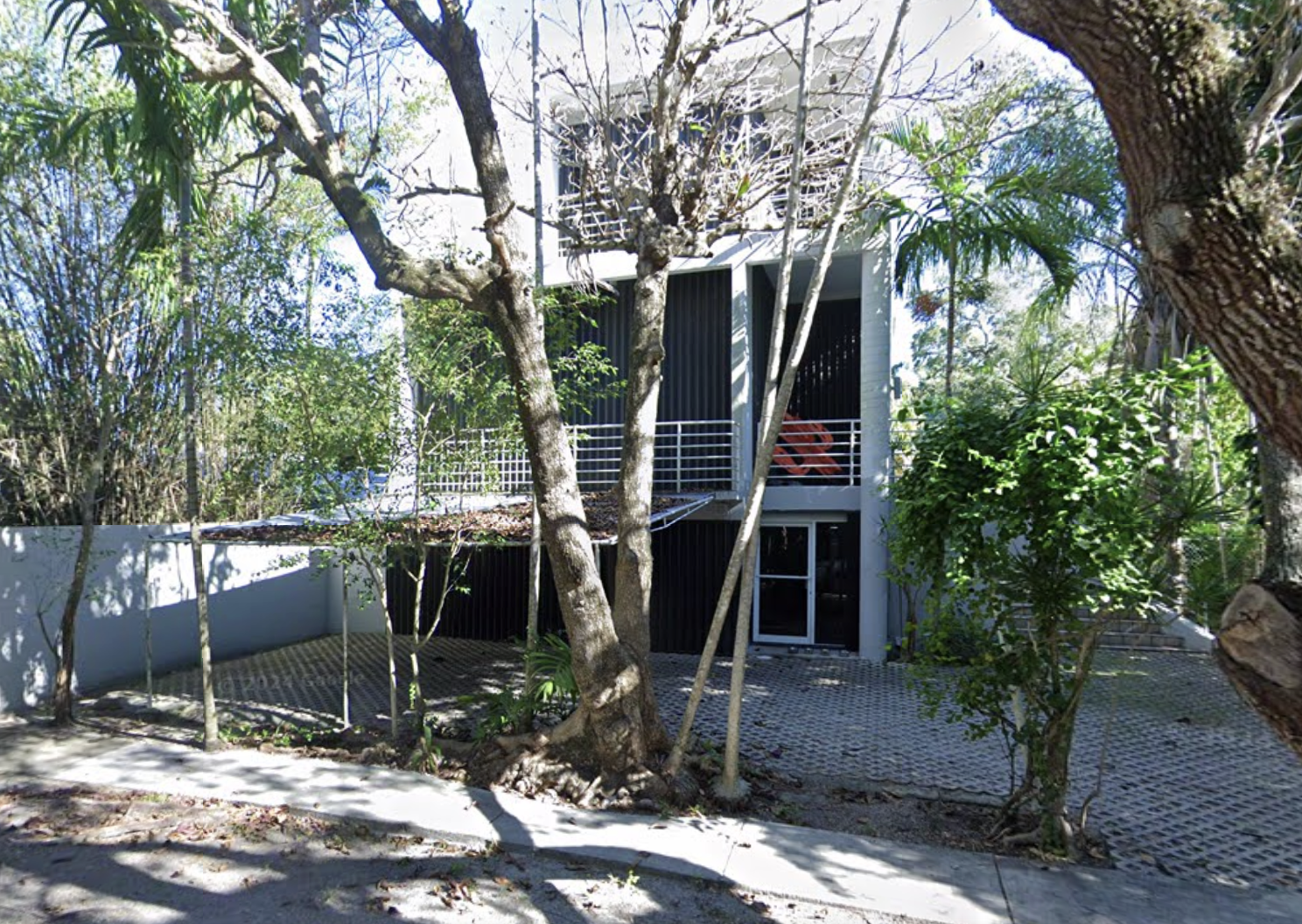 Google Maps screenshot of a three-story villa surrounded by trees and palms