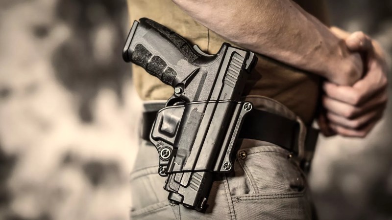 close-up color photo of a holstered handgun on a man's hip