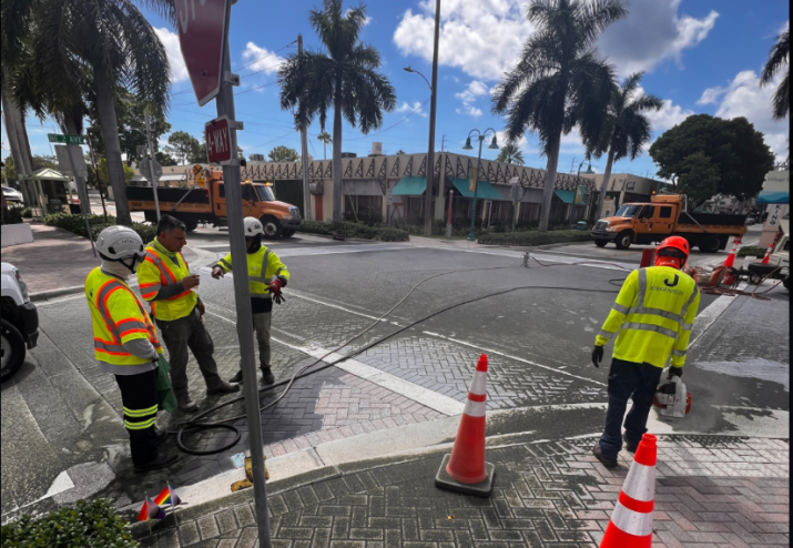 Depicted are state workers sandblasting Delray Beach's pride intersection.